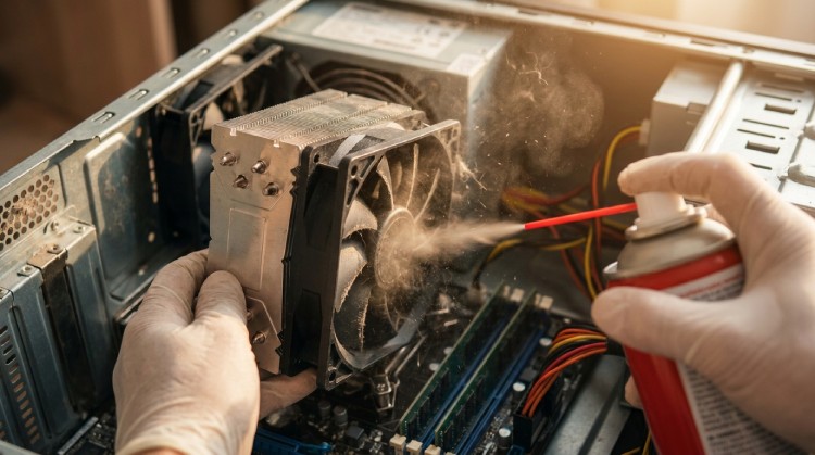A person cleaning a CPU fan with compressed air